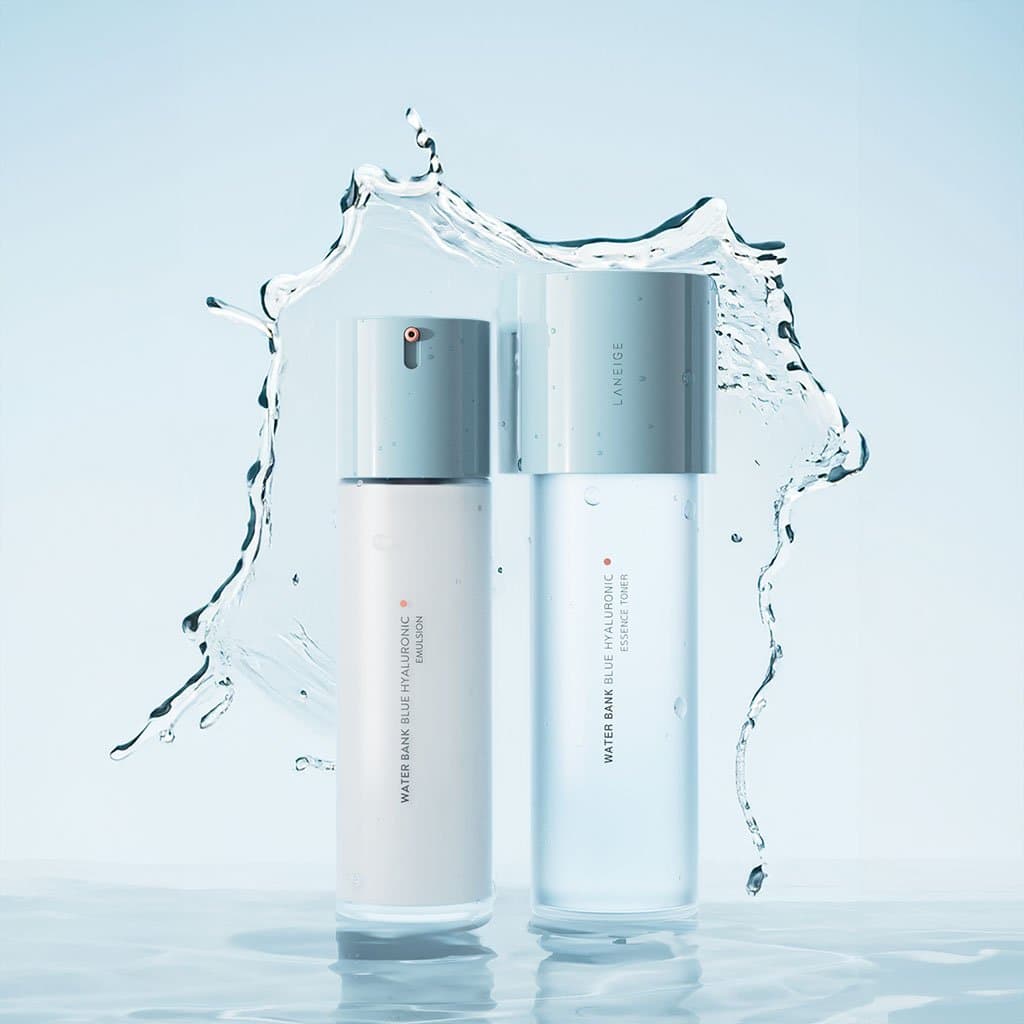 Two Laneige Water Bank bottles in a splash of water against a pale blue sky
