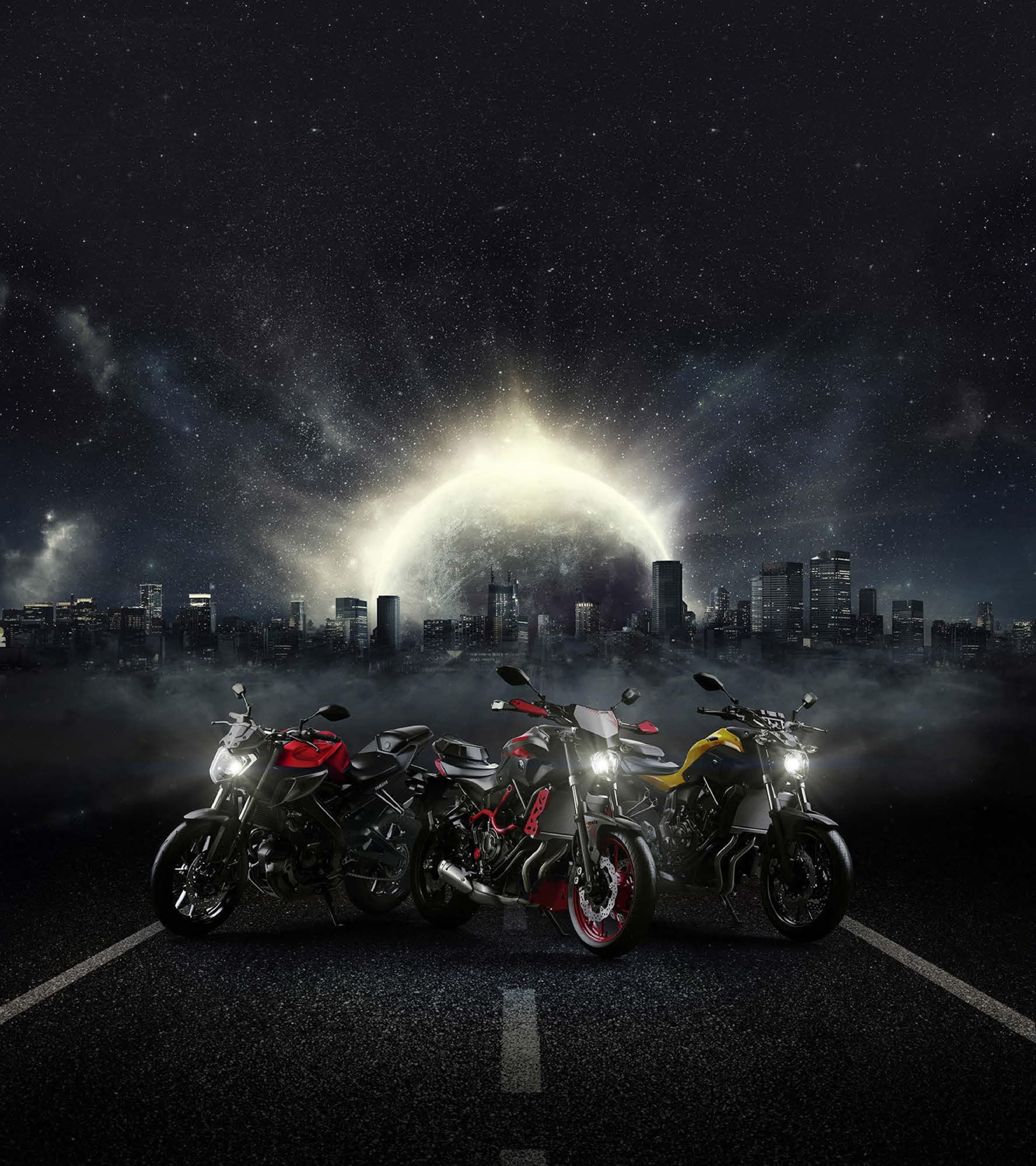 Three CGI motorcycles on a dark road in front of a glowing city